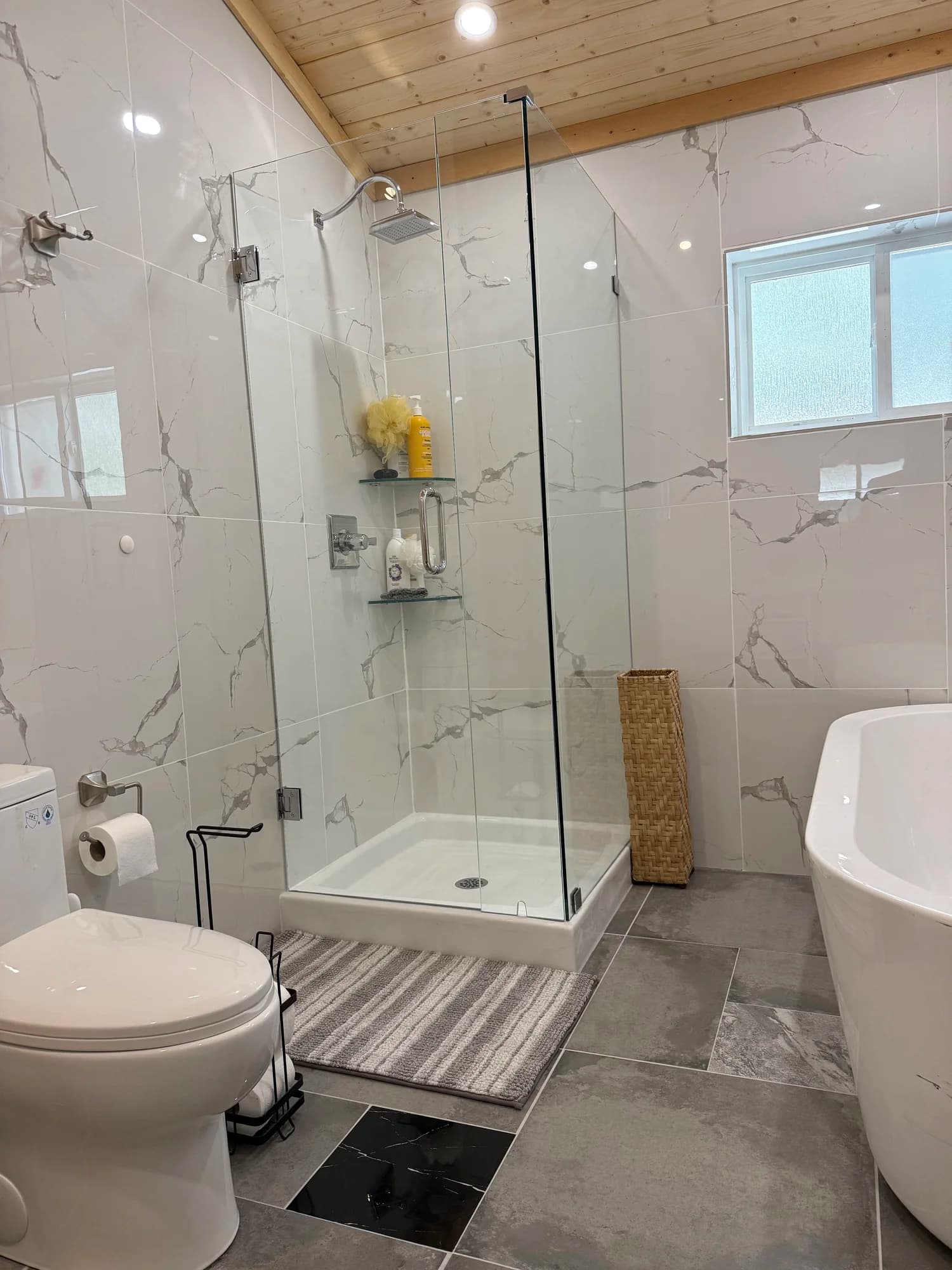 Glass walk-in shower with marble tile